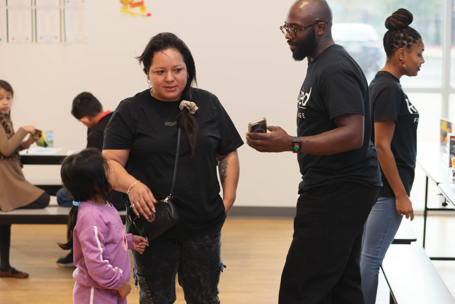 ROOTED for Change team members welcoming families at a community event